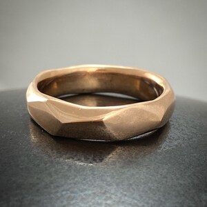 Puede incluir: Un anillo de oro con un dise&ntilde;o facetado y geom&eacute;trico. El anillo est&aacute; hecho de un metal liso y pulido.