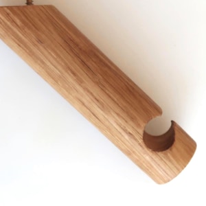 Puede incluir: Un soporte de pared de madera con un gancho curvo, perfecto para colgar abrigos, sombreros o bolsos.