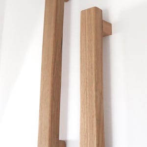 Peut inclure: Une tasse en céramique blanche avec une anse noire et le texte "But First, Coffee" en gras noir. La tasse est posée sur un fond flou, suggérant un cadre chaleureux.