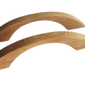 May include: Two wooden arched cabinet pulls, each with a smooth, natural wood finish.