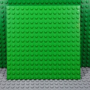 May include: A green Lego baseplate with a grid of studs. The baseplate is made of plastic and is designed for building with Lego bricks.