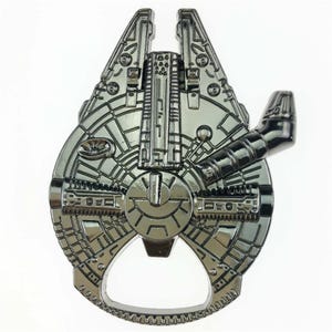 Peut inclure: Un ouvre-bouteille argenté en forme de vaisseau spatial Millennium Falcon. L'ouvre-bouteille présente des panneaux détaillés et un bord pour enlever les bouchons en bas. Le design est une icône reconnaissable d'une franchise de science-fiction populaire.