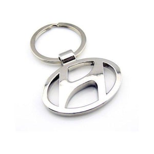 May include: Silver metal keyring featuring a Hyundai logo. The logo is a stylised letter H within a circle.