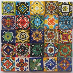 May include: A collection of 25 square ceramic tiles with intricate, colorful patterns. Each tile features a unique design, including floral and geometric motifs in shades of blue, yellow, red, green, and orange. The tiles are arranged in a grid.