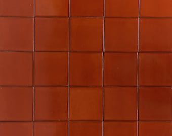 May include: A wall covered in 18 terracotta tiles, each tile is a square shape.