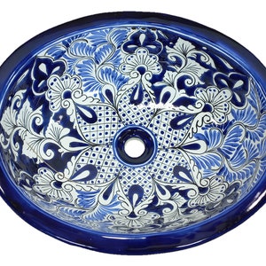 May include: A blue and white ceramic oval sink with a floral design. The sink has a single drain hole in the center.
