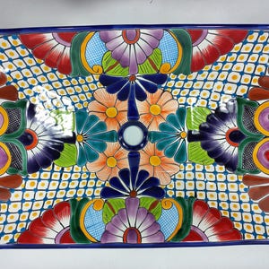 May include: Rectangular ceramic serving platter with a vibrant floral design. The platter features a blue border and a central pattern of colorful flowers in red, orange, purple, and green, set against a white and yellow diamond grid.