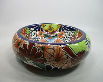 Op de afbeelding: Een kleurrijke keramische kom met een bloemenmotief. De kom is versierd met felle kleuren, waaronder rood, oranje, geel, groen, blauw en paars. De kom heeft een ronde vorm en een brede rand.