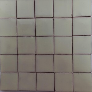 May include: A set of 25 small, square, light green tiles with a slightly textured surface.