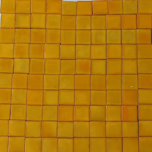 May include: A sheet of small, square, yellow ceramic tiles. The tiles are arranged in a grid pattern.