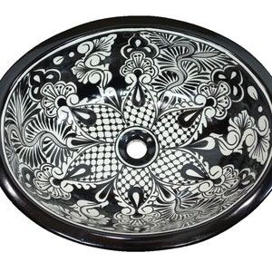 May include: A black and white ceramic vessel sink with a floral design. The sink has a round shape and a black rim.