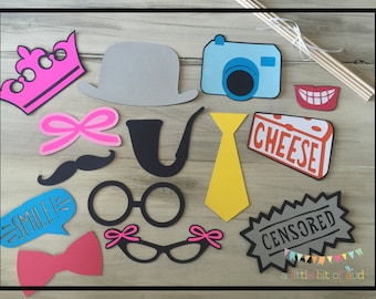May include: A set of 13 colorful photo booth props, including a crown, hat, camera, bow tie, mustache, glasses, bow, pipe, tie, cheese sign, smile sign, and censored sign. The props are printed on cardstock and are ready to be used for a fun photo booth.
