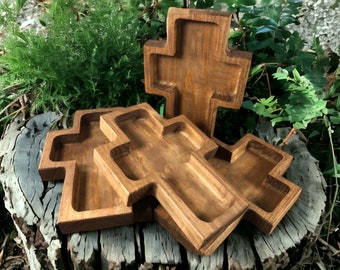 May include: Three wooden cross-shaped trays, stacked on top of each other. The trays are made of dark brown wood and have a smooth, polished finish.