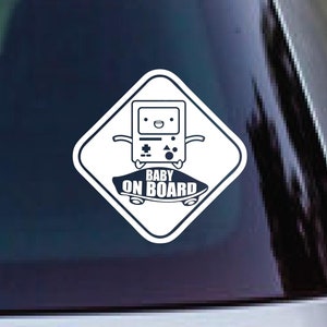 May include: White diamond-shaped sticker with a cartoon video game character on a skateboard. The text "BABY ON BOARD" is written below the character.