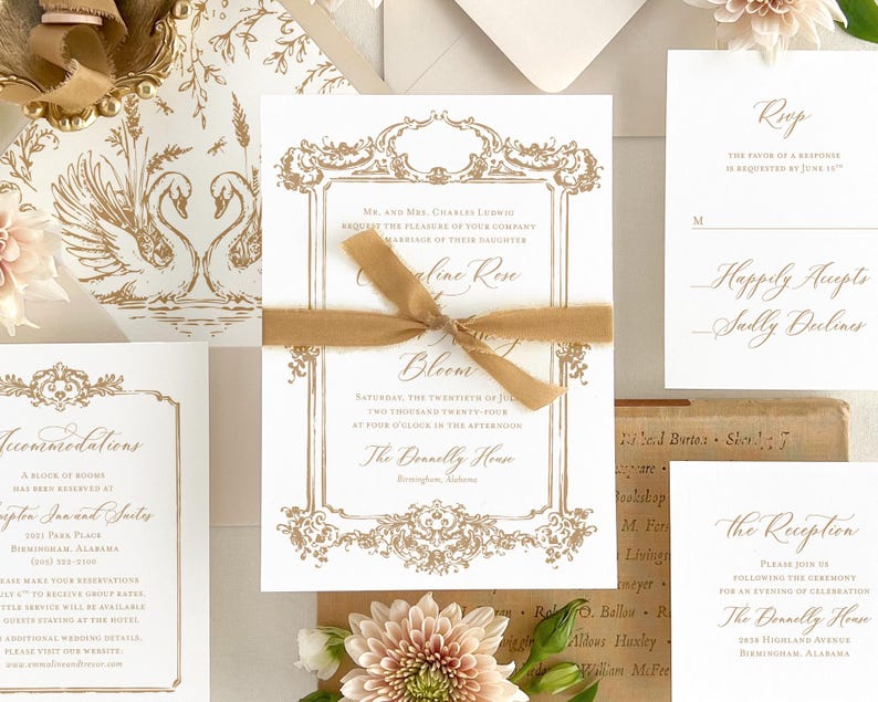May include: Gold foil wedding invitation suite with a swan design. The invitation features a gold foil border with ornate details and the text "Mr. and Mrs. Charles Ludwig request the pleasure of your company at the marriage of their daughter Caroline Rose". The RSVP card features the text "Happily Accepts - Sally Dulines".