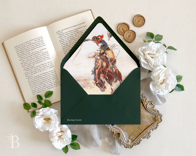 Op de afbeelding: Een donkergroene envelop met de tekst Racing Green op de voorflap. De envelop is geopend en toont een illustratie van een cowboy op een bokkend bruin paard die een lasso vasthoudt. De envelop is omringd door witte rozen.