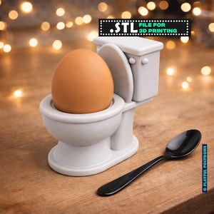 Puede incluir: Un original portahuevos con forma de inodoro en miniatura, blanco, con un huevo marrón en su interior. Una cuchara negra descansa al lado. La imagen incluye el texto ".STL FILE FOR 3D PRINTING".