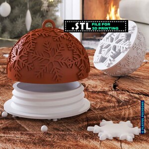 Könnte beinhalten: Ein 3D-gedruckter Weihnachtsschmuck mit Schneeflockenmuster. Der Schmuck besteht aus zwei Teilen: einem braunen Oberteil mit Schneeflockenausschnitten und einem weißen Sockel. Der Text ".STL FILE FOR 3D PRINTING" ist sichtbar.