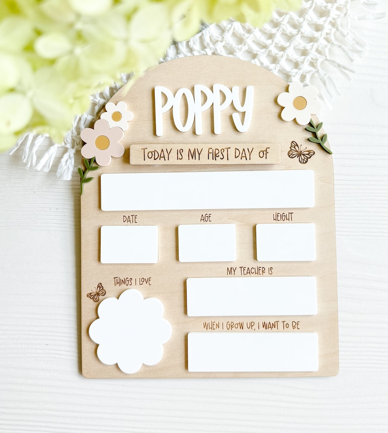 First/Last day of school sign with acrylic flowers and engraved butterflies. Features child's name in choice of acrylic color, and white areas to write milestones with a dry erase marker (not included).