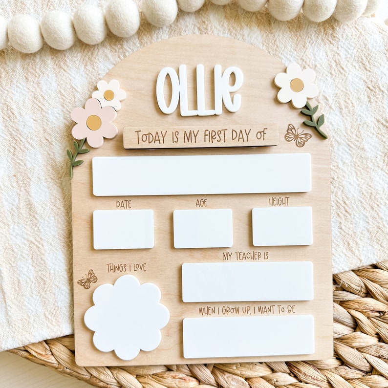 First/Last day of school sign with acrylic flowers and engraved butterflies. Features child's name in choice of acrylic color, and white areas to write milestones with a dry erase marker (not included).