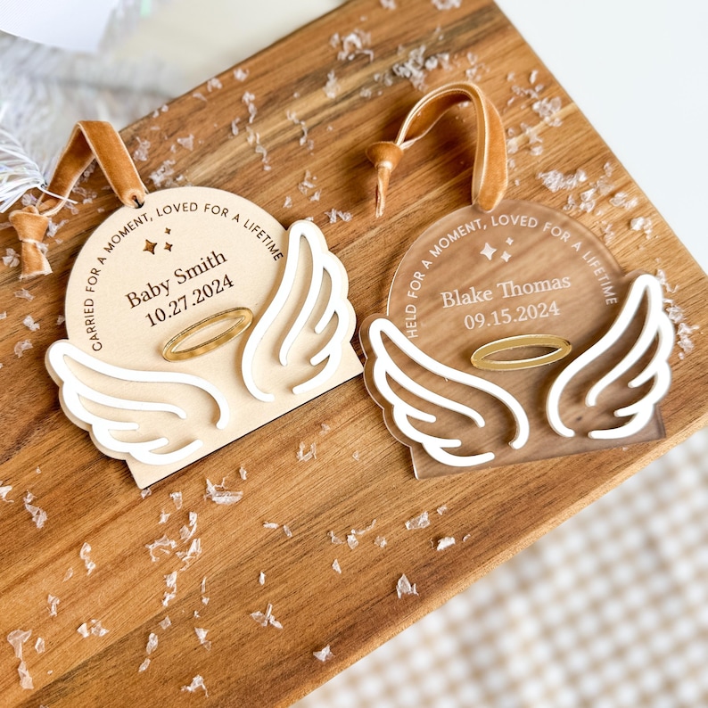 Wood or frosted acrylic baby memorial ornament.  Features matte white acrylic wings and a gold halo.  Personalize with baby's name and date.  Includes khaki velvet ribbon for hanging.