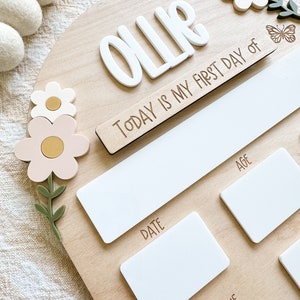 First/Last day of school sign with acrylic flowers and engraved butterflies. Features child's name in choice of acrylic color, and white areas to write milestones with a dry erase marker (not included).