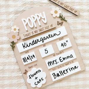 First/Last day of school sign with acrylic flowers and engraved butterflies. Features child's name in choice of acrylic color, and white areas to write milestones with a dry erase marker (not included).