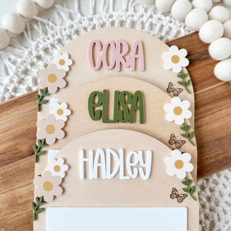 First/Last day of school sign with acrylic flowers and engraved butterflies. Features child's name in choice of acrylic color, and white areas to write milestones with a dry erase marker (not included).