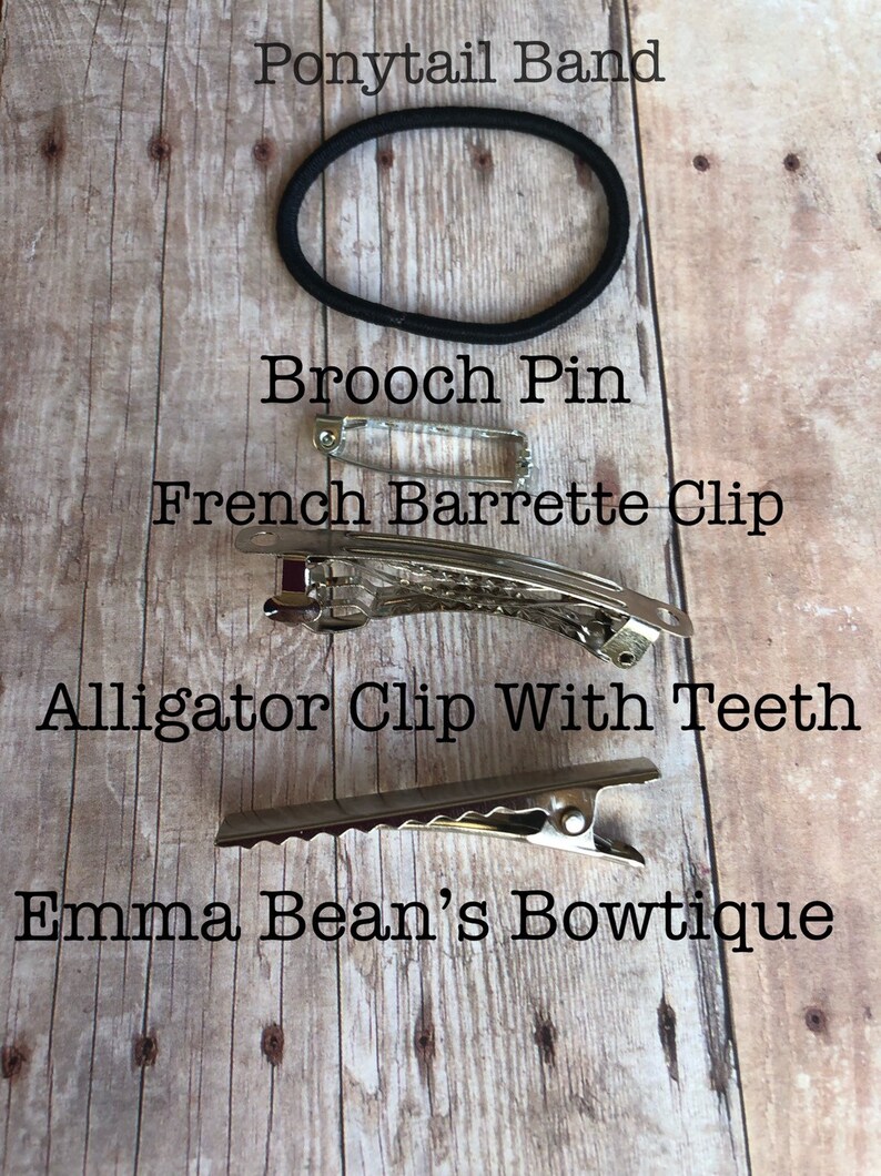 May include: A close-up of four different hair accessories on a wooden surface. The accessories include a ponytail band, a brooch pin, a French barrette clip, and an alligator clip with teeth. The text "Emma Bean's Bowtique" is visible at the bottom of the image.