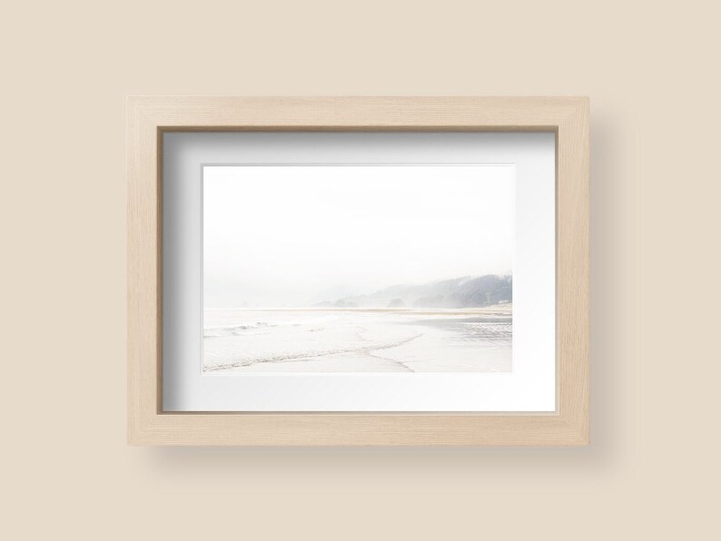 May include: A framed photograph of a beach scene with a misty, hazy background and a shoreline with waves crashing on the sand.