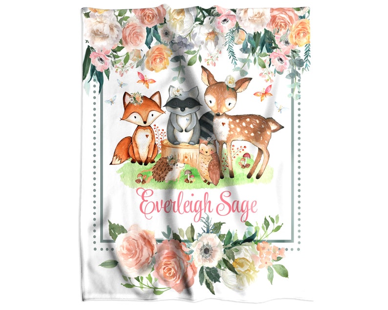 a personalized minky blanket with a picture of a fox, a raccoon, a deer and a hedgehog surrounded with beautiful flower in pink cream and peach