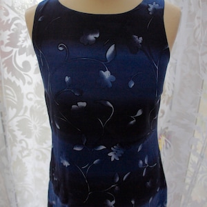 May include: A sleeveless blue dress with a white floral print. The dress has a gradient pattern, fading from dark blue to light blue.