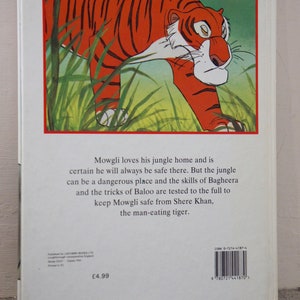 Puede incluir: La contraportada de un libro infantil sobre Mowgli de El Libro de la Selva. La portada presenta una ilustraci&oacute;n de un tigre caminando por la hierba alta y verde. El texto en la contraportada dice: "Mowgli ama su hogar en la selva y est&aacute; seguro de que siempre estar&aacute; a salvo all&iacute;. Pero la selva puede ser un lugar peligroso y las habilidades de Bagheera y los trucos de Baloo se ponen a prueba para mantener a Mowgli a salvo de Shere Khan, el tigre devorador de hombres."