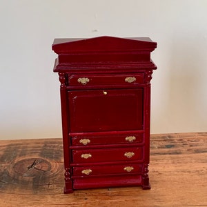 Op de afbeelding: Een mahoniekleurig houten secretaressebureau met een neerlaatbare voorkant en vier laden. Het bureau heeft goudkleurige beslag.