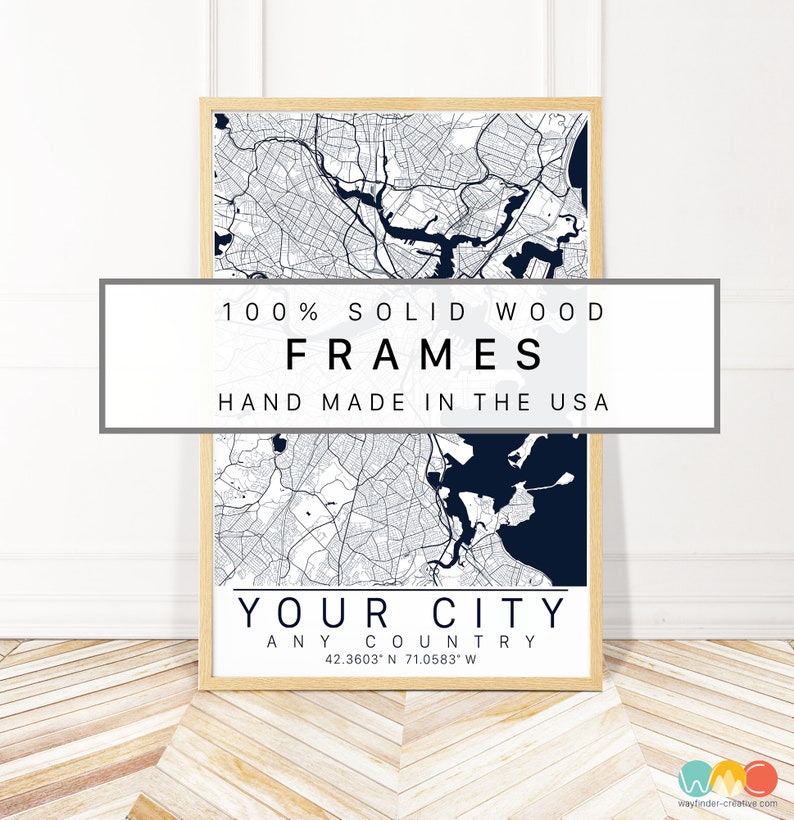 May include: A framed map of a city with a navy blue and white color scheme. The frame is made of solid wood and the map is labeled "Your City" with the coordinates 42.3603 N 71.0583 W. The text "100% Solid Wood Frames Hand Made in the USA" is printed on a white rectangle at the top of the image.