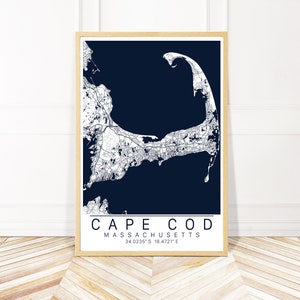 May include: A navy blue print of a map of Cape Cod, Massachusetts. The map shows the outline of the Cape with roads and towns. The text "Cape Cod, Massachusetts 34.0235' S 18.4721' E" is printed below the map.