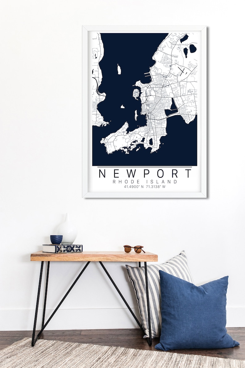 May include: A framed map of Newport, Rhode Island, with a white background and navy blue water. The map shows the city streets and coastline. The text "NEWPORT" and "RHODE ISLAND" are printed below the map, along with the coordinates "41.4900&deg; N 71.3138&deg; W".