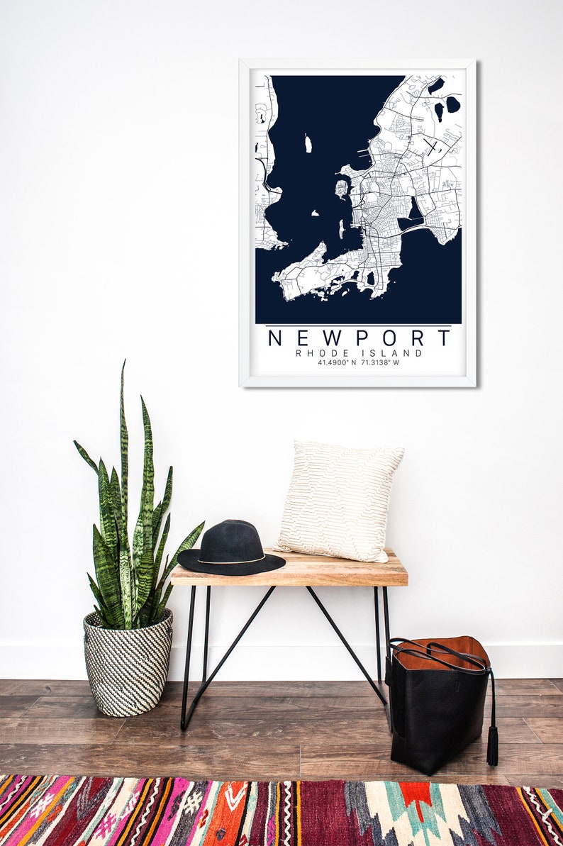 May include: A framed map of Newport, Rhode Island, with a white frame and a dark blue background. The map shows the city's streets and waterways. The text "NEWPORT RHODE ISLAND 41.4900&deg;N 71.3138&deg;W" is printed below the map.