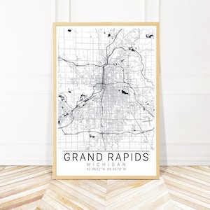 May include: A black and white map print of Grand Rapids, Michigan. The map shows the city's streets and landmarks. The text "Grand Rapids, Michigan 42.9632° N 85.6679° W" is printed below the map.