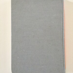 May include: A gray hardcover book with a red spine.