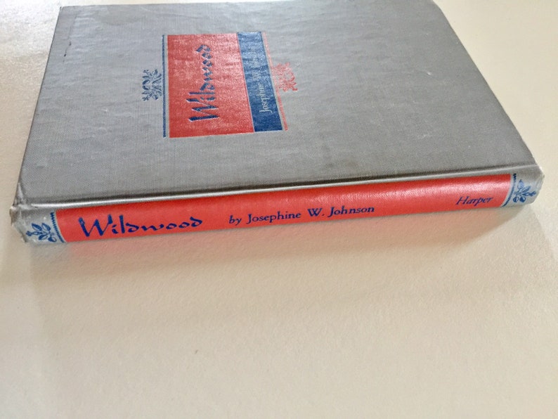 May include: A red hardcover book with the title "Wildwood" by Josephine W. Johnson and the publisher "Harper" printed on the spine.