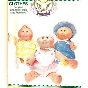 May include: A vintage Butterick pattern for Cabbage Patch Kids Preemie clothes. The cover features three Cabbage Patch Kids dolls wearing yellow, pink, and blue outfits. The pattern includes the text "CLOTHES" and "Preemie!"