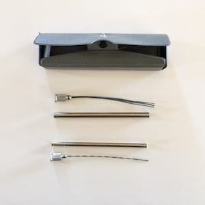 May include: A set of three silver soldering irons with a gray metal case. The soldering irons have a silver tip and a black wire.