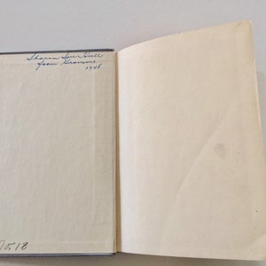 May include: A white book with blue writing on the cover. The writing says "Sharon Sue Hall from Grandma 1945" and "No. 18".