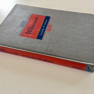May include: A gray hardcover book titled "Willows" by Josephine W. Johnson. The book has a red spine with the title and author's name printed in blue. The publisher, Harper, is printed in blue on the bottom of the spine.