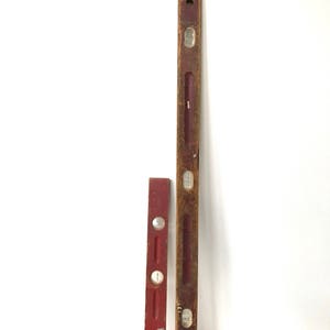 May include: Two vintage wooden levels, one red and one brown, with metal bubble vials. The levels are both about 18 inches long.