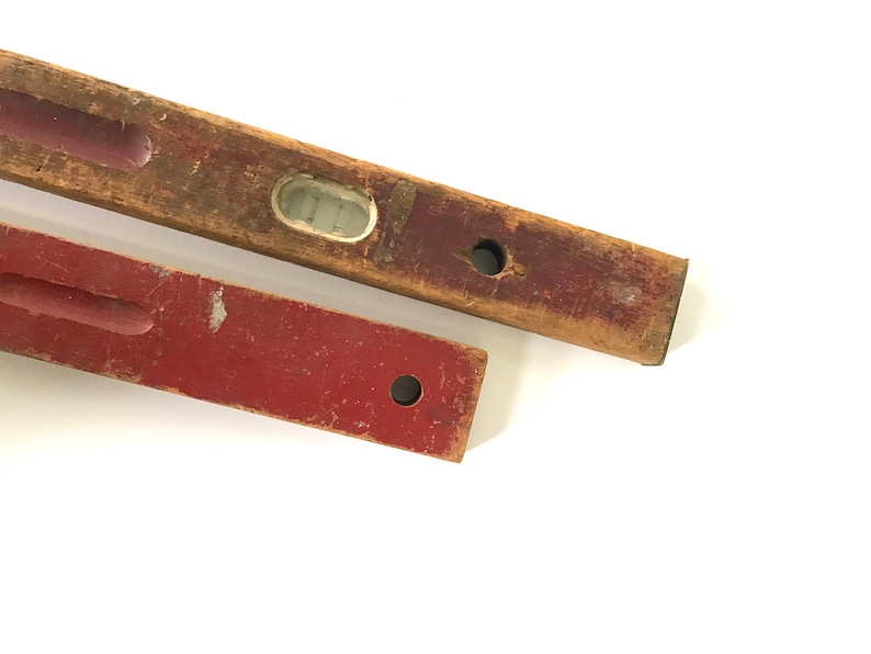 May include: Two wooden level tools, one is red and the other is brown with a visible level bubble.