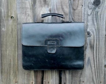 Bolso bandolera de cuero negro estilo años 90, tipo maletín o bandolera.