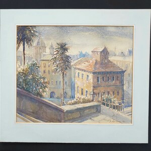 May include: Watercolor painting of a European cityscape with buildings, palm trees, and a domed structure in the background. The artwork is framed with a light blue mat and signed in the lower right corner.