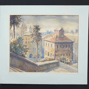 May include: Watercolor painting of a European cityscape with buildings, palm trees, and a domed structure in the background. The artwork is framed with a light blue mat and signed in the lower right corner.